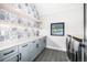 Bright laundry room features patterned wallpaper, floating shelves, and modern washer and dryer at 1685 S Milwaukee St, Denver, CO 80210