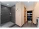Modern bathroom features tiled walk-in shower with built-in niche and storage cabinet with stacked towels at 3313 Curtis St, Denver, CO 80205