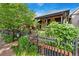 Street-side exterior shot with garden, decorative iron fence, and great curb appeal at 3313 Curtis St, Denver, CO 80205