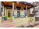 Inviting front porch with seating, bright door, and wooden ceiling, perfect for relaxing and enjoying the outdoors at 3313 Curtis St, Denver, CO 80205