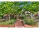 Charming home exterior with lush front yard featuring garden beds, trees, and a walkway leading to the porch at 3313 Curtis St, Denver, CO 80205