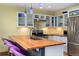 Open kitchen boasts wood countertops, stainless appliances, gas range, and seating at the island at 3313 Curtis St, Denver, CO 80205