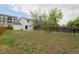 Large backyard with lawn, wooden fence, and view of apartment building at 13438 E 13Th Pl, Aurora, CO 80011