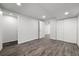 Finished basement with wood-look flooring, featuring closets and an open doorway at 13438 E 13Th Pl, Aurora, CO 80011