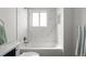 Bright bathroom showcases white marble-style tile throughout the shower and tub area at 13438 E 13Th Pl, Aurora, CO 80011