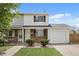 Charming two-story townhome with brick accents, a well-manicured lawn, and a convenient attached garage at 13438 E 13Th Pl, Aurora, CO 80011