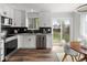 Bright kitchen with white cabinetry, stainless steel appliances, and sliding doors to the backyard at 13438 E 13Th Pl, Aurora, CO 80011