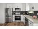 Modern kitchen featuring stainless steel appliances, sleek white cabinetry, and dark subway tile backsplash at 13438 E 13Th Pl, Aurora, CO 80011