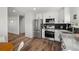 Modern kitchen featuring stainless steel appliances, white cabinets, and an open layout with stairs at 13438 E 13Th Pl, Aurora, CO 80011