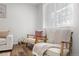 Bright living room with modern chairs, wood floors, and a sheer curtain-covered window at 13438 E 13Th Pl, Aurora, CO 80011