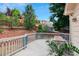 Back deck with a dining table and view of the terraced yard and hillside landscaping at 3575 W Hamilton Pl, Denver, CO 80236