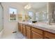 Bathroom with dual sinks, vanity with cabinets, a large mirror and a shower and tub with glass doors at 3575 W Hamilton Pl, Denver, CO 80236