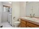 Bright bathroom with a sink, vanity, and combined laundry area with a washer and dryer at 3575 W Hamilton Pl, Denver, CO 80236