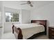 Bedroom with a neutral color scheme, large window, cozy bed, and a dresser, creating a calming atmosphere at 3575 W Hamilton Pl, Denver, CO 80236