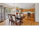 Open-concept kitchen and dining area featuring hardwood floors and stainless steel appliances at 3575 W Hamilton Pl, Denver, CO 80236