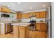 Bright kitchen with stainless steel appliances, an island, and ample cabinet space at 3575 W Hamilton Pl, Denver, CO 80236