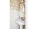 Elegant powder room with stylish wallpaper, a pedestal sink, and a gold-framed mirror at 4131 Quivas St, Denver, CO 80211
