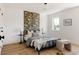 Bright bedroom with decorative accent wall, modern black frame bed, and light hardwood floors at 4131 Quivas St, Denver, CO 80211