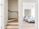 Bedroom view from staircase featuring stylish furniture, hardwood floors, and a decorative accent wall at 4131 Quivas St, Denver, CO 80211