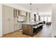 Bright open kitchen featuring a large island with seating, modern appliances, and hardwood flooring, perfect for cooking at 4131 Quivas St, Denver, CO 80211
