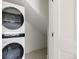 Modern laundry room featuring stacked washer and dryer and unique patterned tile floors at 4131 Quivas St, Denver, CO 80211
