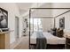 Bright main bedroom with a four-poster bed, and a comfortable seating area by the window at 4131 Quivas St, Denver, CO 80211