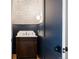 Stylish powder room features patterned wallpaper, a blue accent wall, and dark wood vanity at 4131 Quivas St, Denver, CO 80211