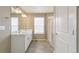 Bright bathroom with a double sink vanity, tiled floor, and glass shower at 18399 Field Mint Pt, Parker, CO 80134