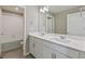 Modern bathroom with double sinks, white cabinetry, and a tub with shower at 18399 Field Mint Pt, Parker, CO 80134