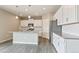Modern kitchen featuring white cabinets, stainless steel appliances, and an island with a sink at 18399 Field Mint Pt, Parker, CO 80134