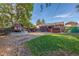 Backyard featuring a small playhouse, trampoline, and mature trees, providing a playful outdoor space at 1591 S Zuni St, Denver, CO 80223