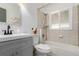 Bright bathroom with tiled shower-tub combo, window, and updated vanity at 1591 S Zuni St, Denver, CO 80223