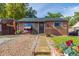 Charming brick home featuring a well-manicured lawn, covered porch, and a cozy swing at 1591 S Zuni St, Denver, CO 80223