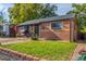 Well-kept single-story brick home with a lush green lawn and charming swing, offering suburban comfort at 1591 S Zuni St, Denver, CO 80223
