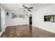 Open concept living room featuring hardwood floors, fresh paint, a ceiling fan, built in shelving and bright natural light at 1591 S Zuni St, Denver, CO 80223