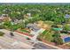 Aerial view of a gray home with a driveway, a tennis court, a pool, and mature trees in the neighborhood at 10197 E Mississippi Ave, Aurora, CO 80247