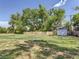 Lush backyard with mature trees, a shed, and well-maintained lawn space for recreation and relaxation at 10197 E Mississippi Ave, Aurora, CO 80247