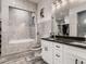 Well-lit bathroom featuring double sinks, a spacious shower, and gray tile flooring at 10197 E Mississippi Ave, Aurora, CO 80247