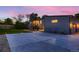 Exterior view of home showcasing the entryway, a wide driveway, and tasteful landscaping at dusk at 10197 E Mississippi Ave, Aurora, CO 80247