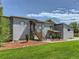 Exterior home elevation showing the entryway, walkway, manicured lawn, and tasteful landscaping at 10197 E Mississippi Ave, Aurora, CO 80247