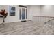 Bright foyer featuring gray wood-look floors, large windows, white walls, and a wooden staircase at 10197 E Mississippi Ave, Aurora, CO 80247