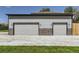 Exterior view of a detached two-car garage with stone accents and a wide driveway at 10197 E Mississippi Ave, Aurora, CO 80247