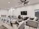 Cozy living room with large sofas, a ceiling fan, a large screen TV, and gray wood-look floors at 10197 E Mississippi Ave, Aurora, CO 80247