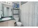 Bathroom with a single sink vanity, framed art and shower with decorative curtain at 8500 E Jefferson Ave # 3H, Denver, CO 80237