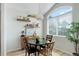 Cozy dining area with a round table, modern light fixture, and a large window offering natural light at 8500 E Jefferson Ave # 3H, Denver, CO 80237
