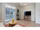 Comfortable living room area with a balcony, TV, and wood-style flooring, perfect for relaxing or entertaining at 8500 E Jefferson Ave # 3H, Denver, CO 80237