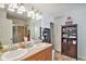 Bright bathroom featuring a double sink vanity, glass shower, and tile flooring at 11833 Oak Hill Way # E, Commerce City, CO 80640