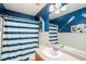 Nautical-themed bathroom featuring a vanity sink, mirror, and a blue striped shower curtain at 11833 Oak Hill Way # E, Commerce City, CO 80640