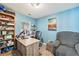 Bright office with a wooden desk, blue walls, and a comfortable armchair at 11833 Oak Hill Way # E, Commerce City, CO 80640