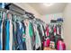 A walk-in closet with white metal shelving is filled with clothing and suitcases at 11833 Oak Hill Way # E, Commerce City, CO 80640